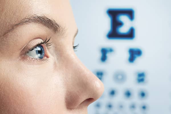 Post corneal surgery patient during an eye examination with a Snellen chart